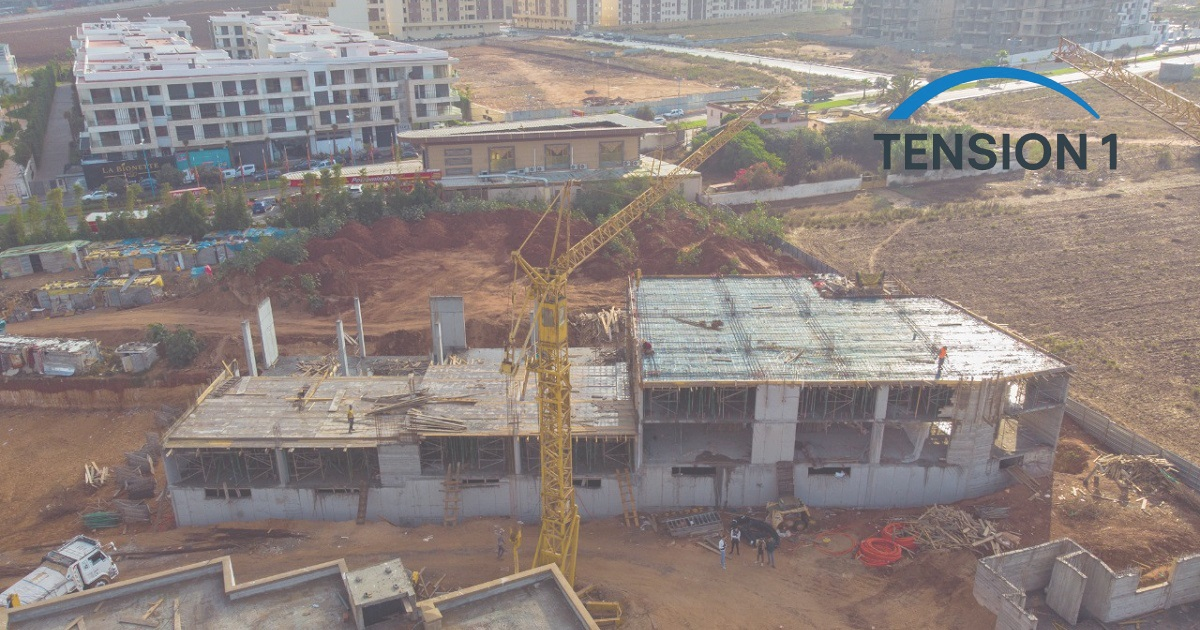Aerial view of a two-level concrete frame under construction, slab reinforcement in place before the pour, the stage where a post tension slab saves concrete