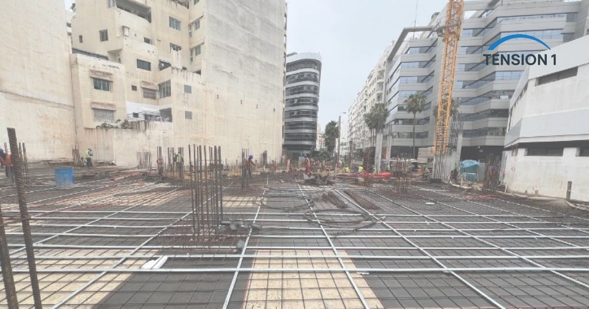 Deck reinforcement and column starter bars on an urban site before the pour, the steel later hidden inside a post tension slab