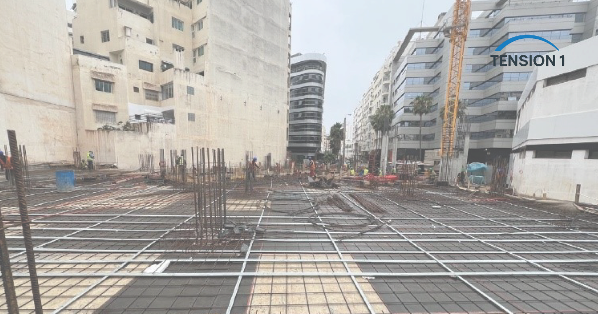 Deck reinforcement and column starter bars on an urban site before the pour, the steel later hidden inside a post tension slab