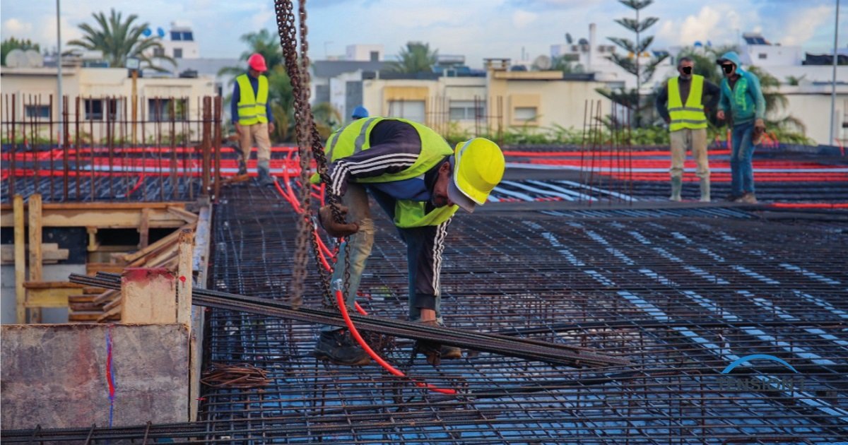 Crew placing a two-layer rebar mat on a reinforced concrete deck, the conventional alternative to a post tension slab