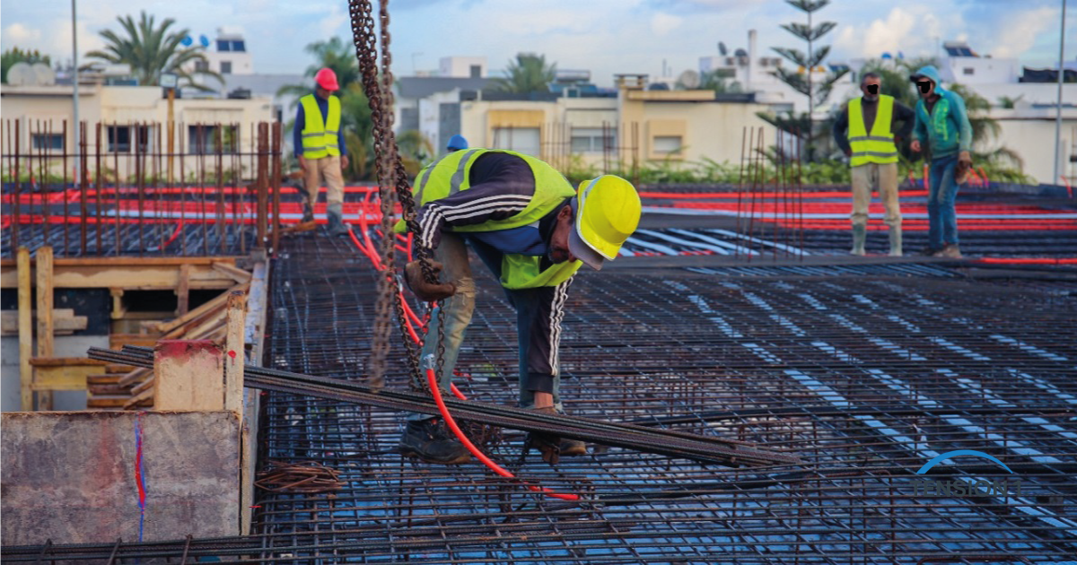 Crew placing a two-layer rebar mat on a reinforced concrete deck, the conventional alternative to a post tension slab
