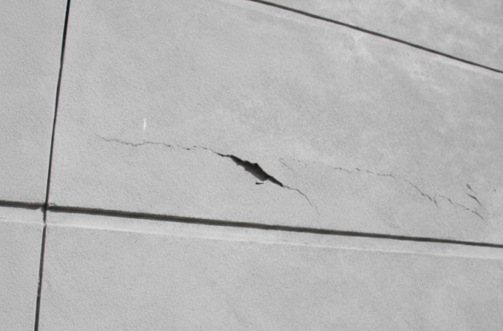 Building facade with visible cracking, a symptom that calls for checking the post tension slab behind it