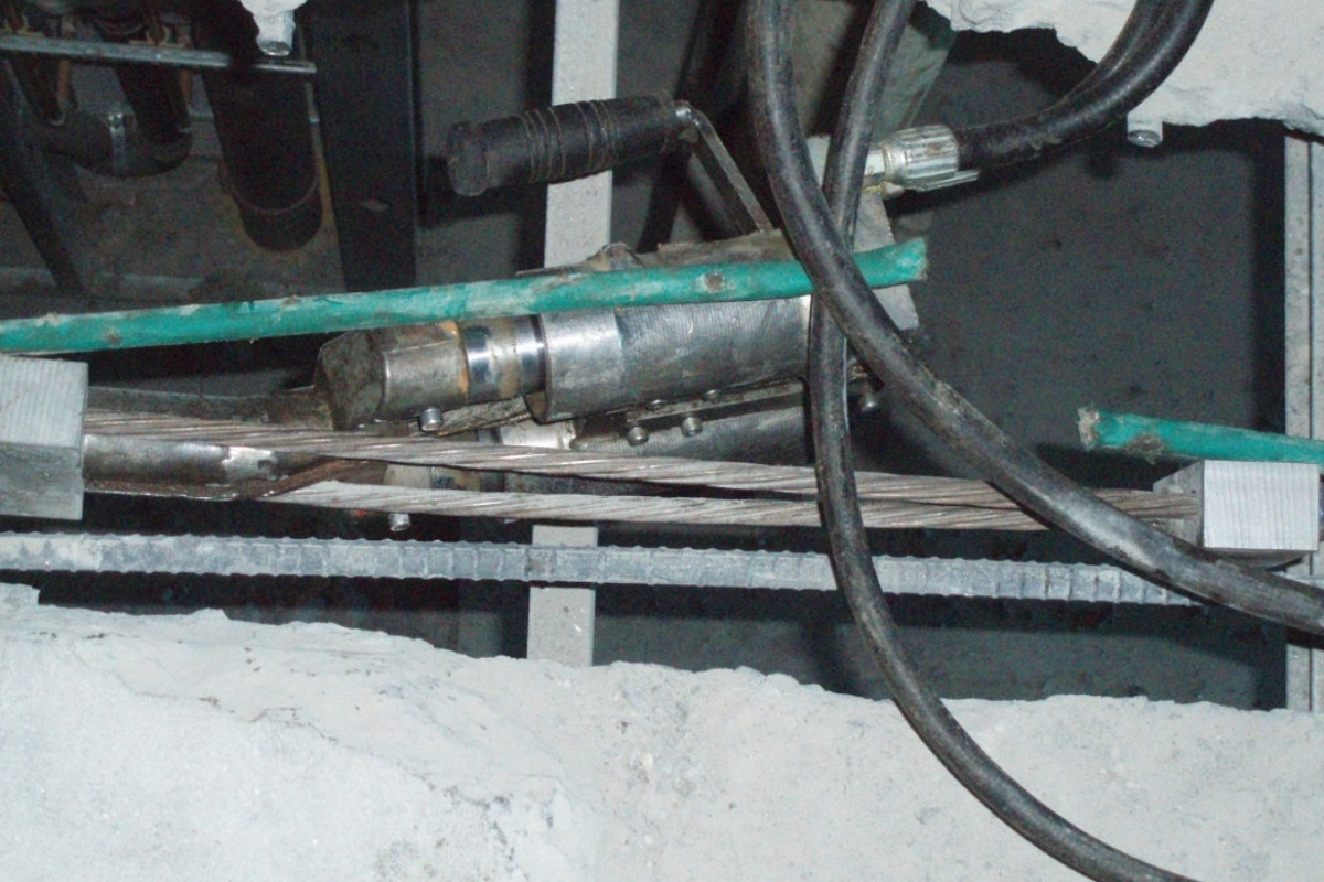 Technicians stressing repaired strands at an opening in a post tension slab