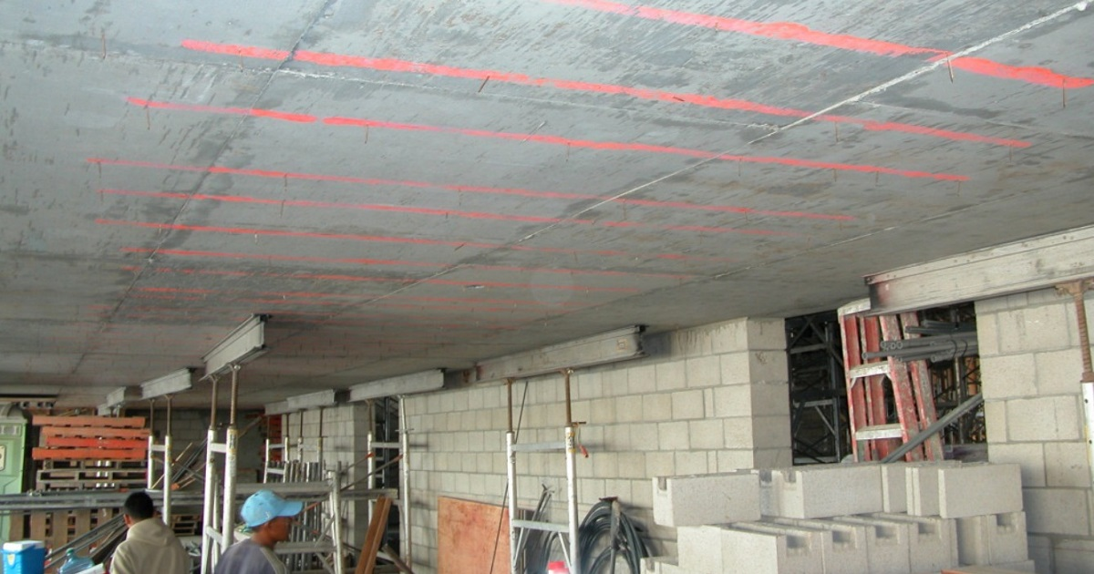 Engineer inspecting an anchor pocket at the edge of a post tension slab